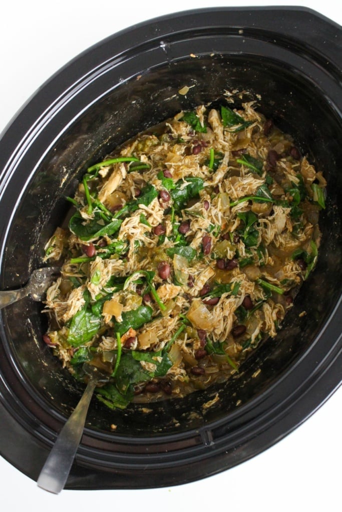 shredded chicken in a crock pot with spinach