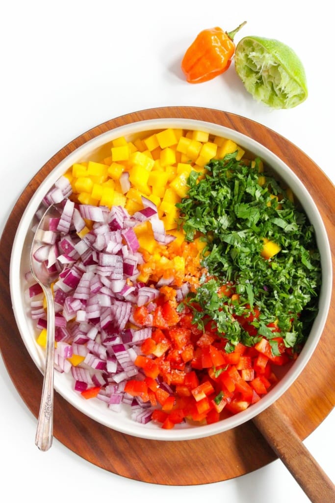 chopped mango, red onion, bell pepper, habanero, and herbs in a bowl