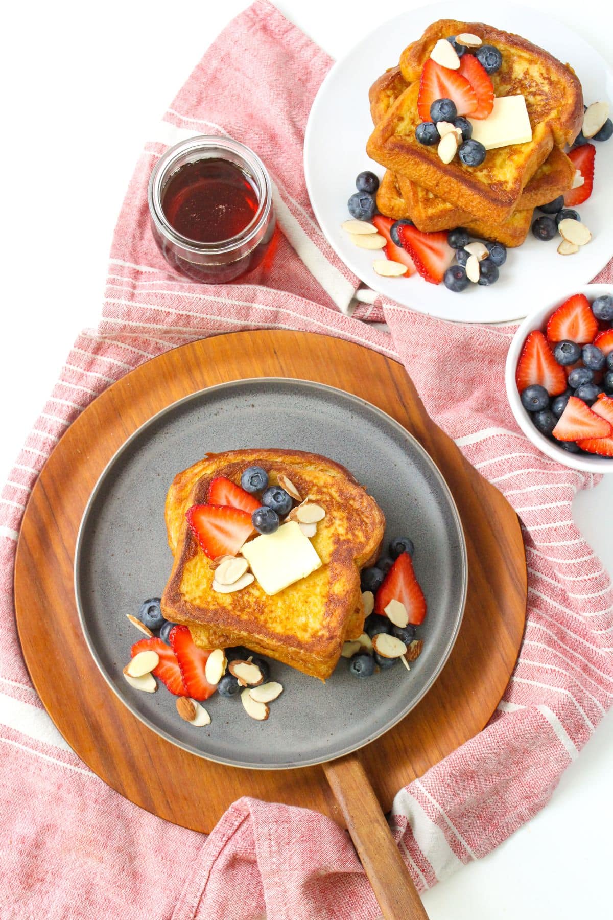 Almond milk french toast on a plate with berries and a knob of butter