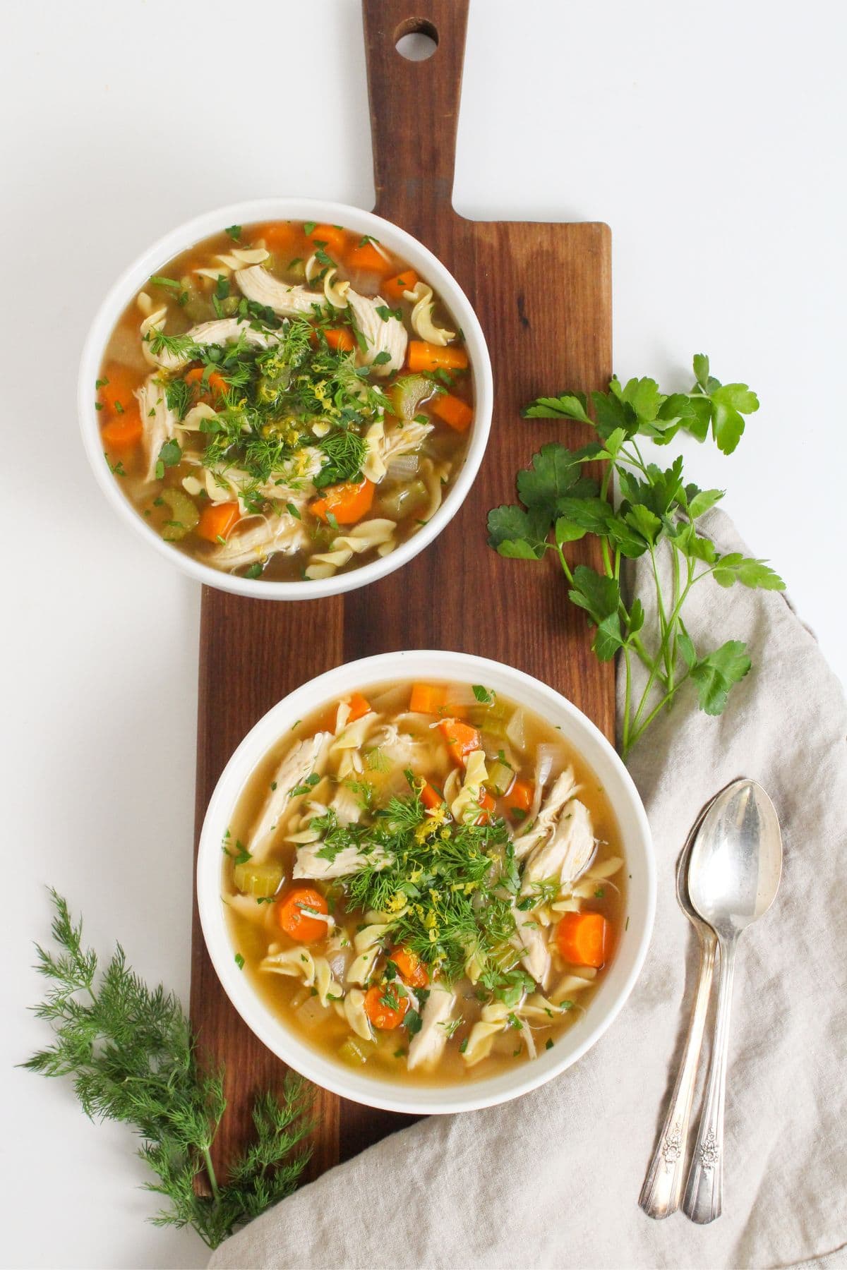 slow cooker chicken noodle soup in bowls on a wooden platter