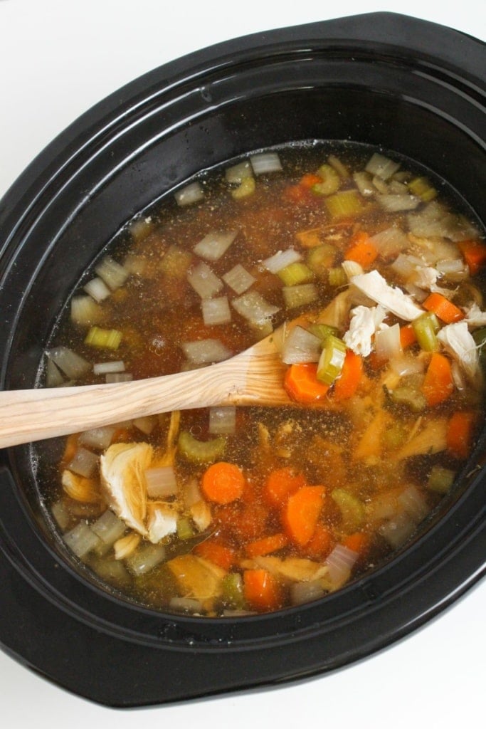 chicken and vegetables with broth in a slow cooker