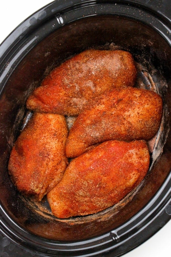 seasoned chicken breasts in a slow cooker insert