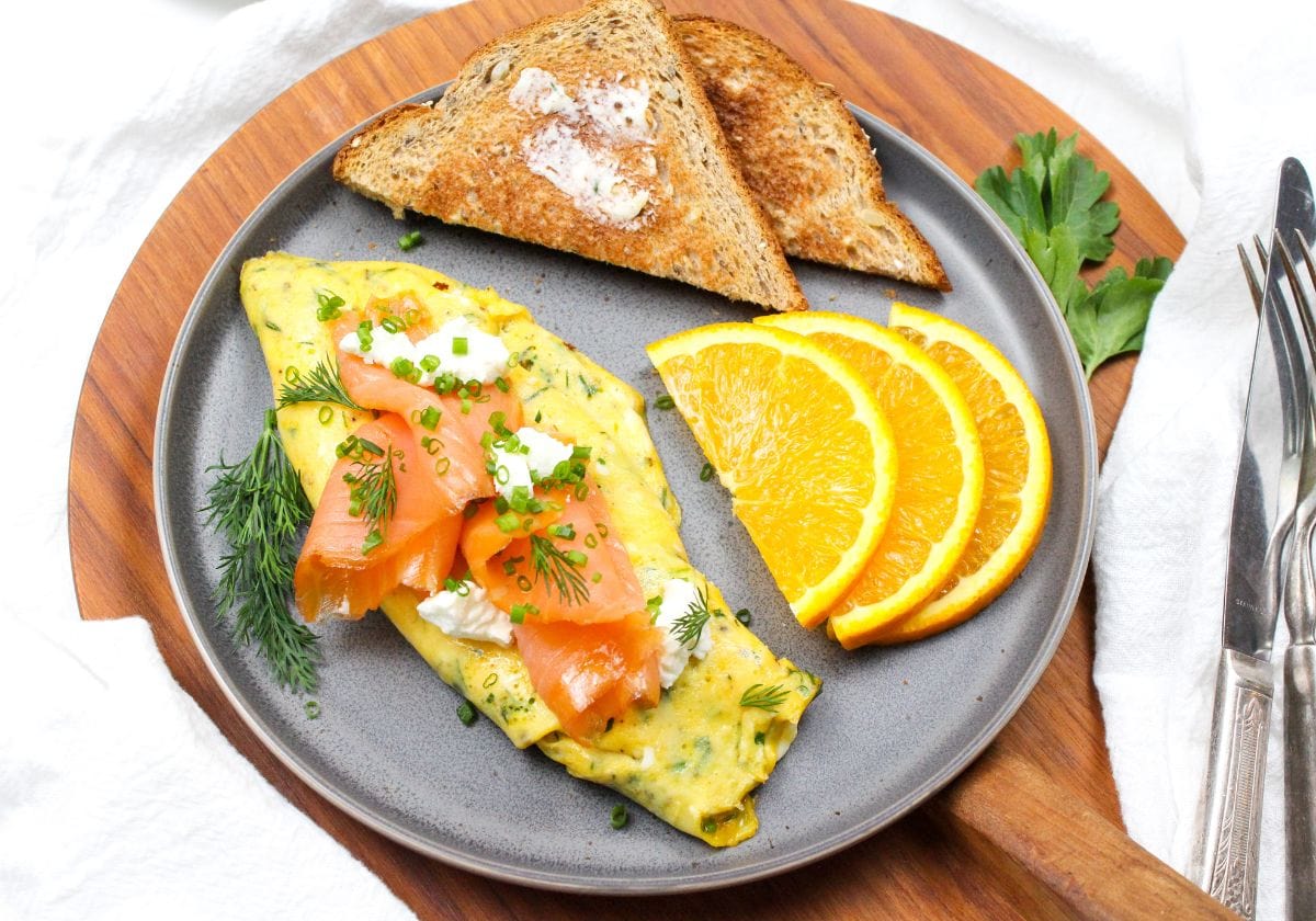 smoked salmon omelette with goat cheese on a plate with orange slices