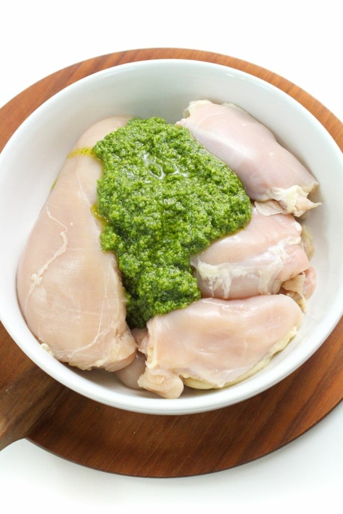 raw chicken in a bowl with pesto sauce