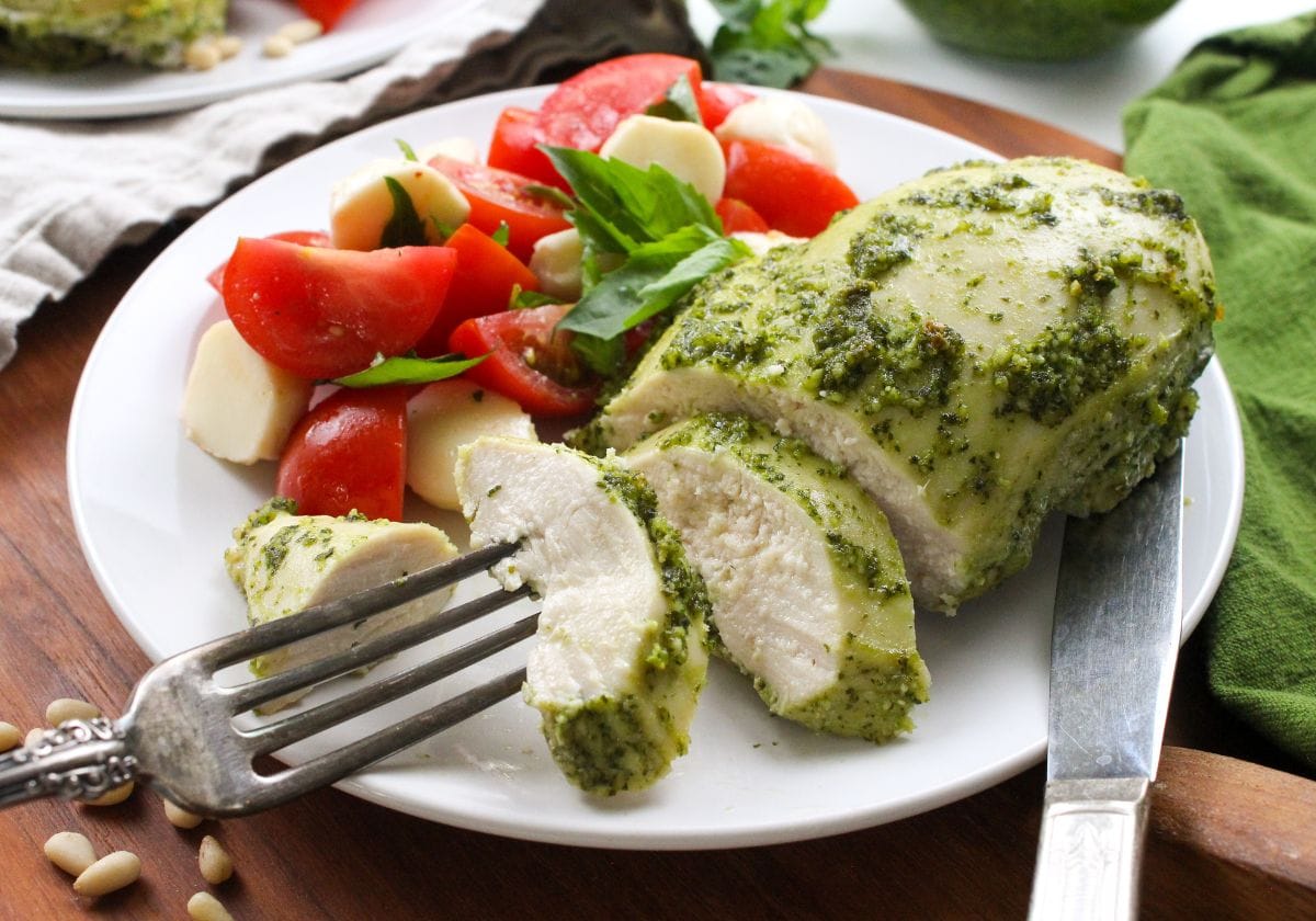 baked pesto chicken and caprese salad on a plate