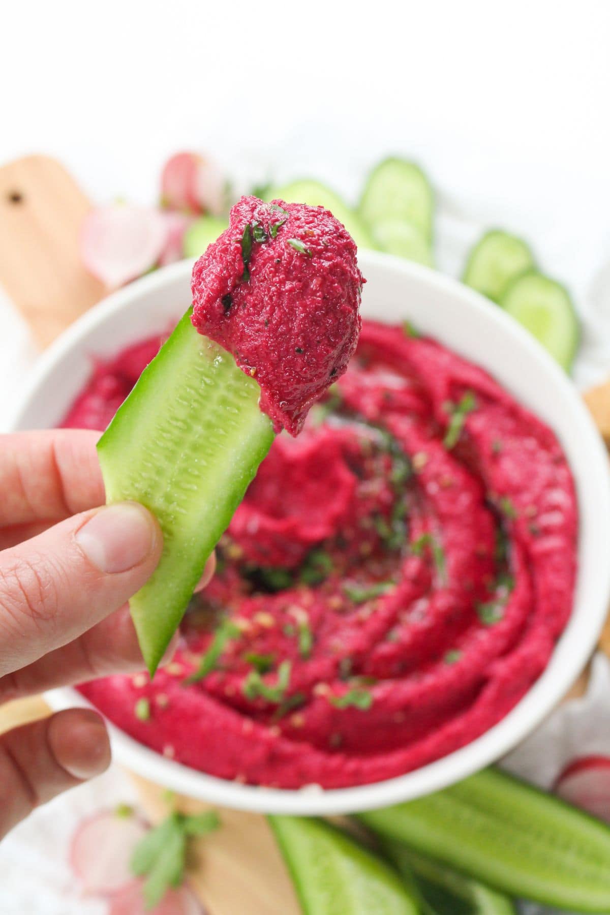 cucumber spear dipped in hummus