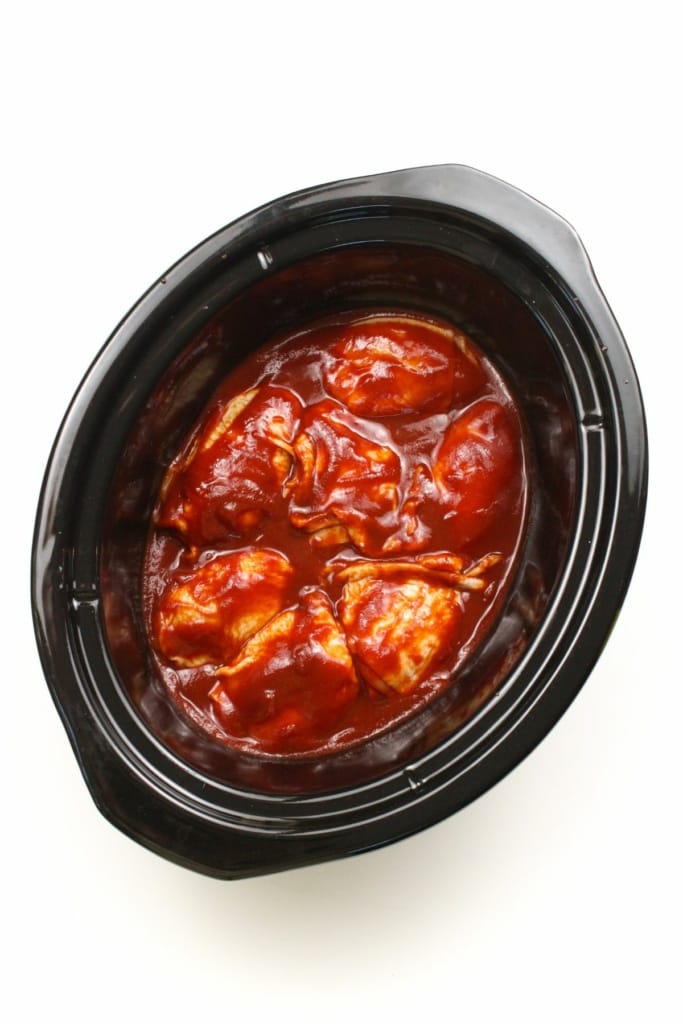 bbq sauce and chicken thighs in a slow cooker