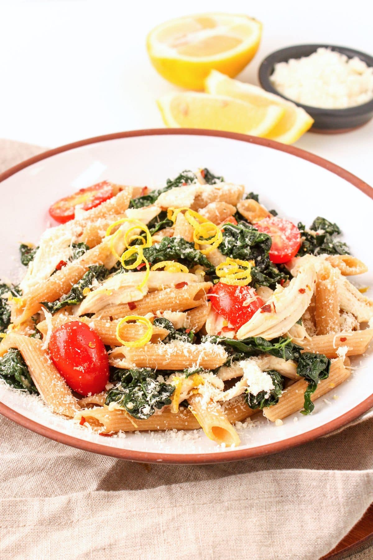 lemon kale pasta with shredded chicken, parmesan cheese, and tomatoes