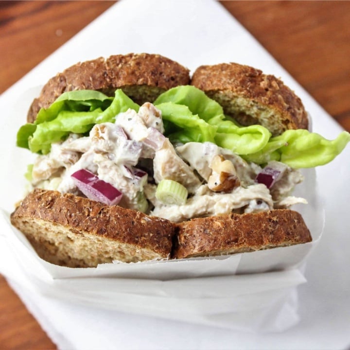 shredded chicken salad sandwich on a wooden platter