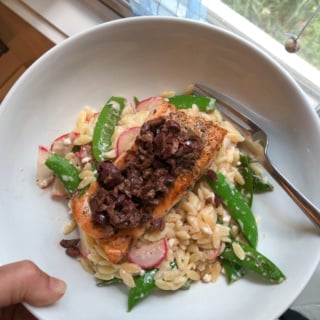salmon in a bowl with orzo and olives