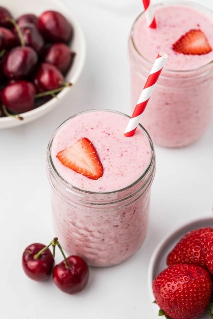 cherry strawberry smoothie with lemon in a mason jar with a striped straw