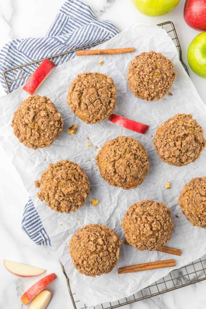 apple cinnamon crumb muffins on a wire rack with parchment paper