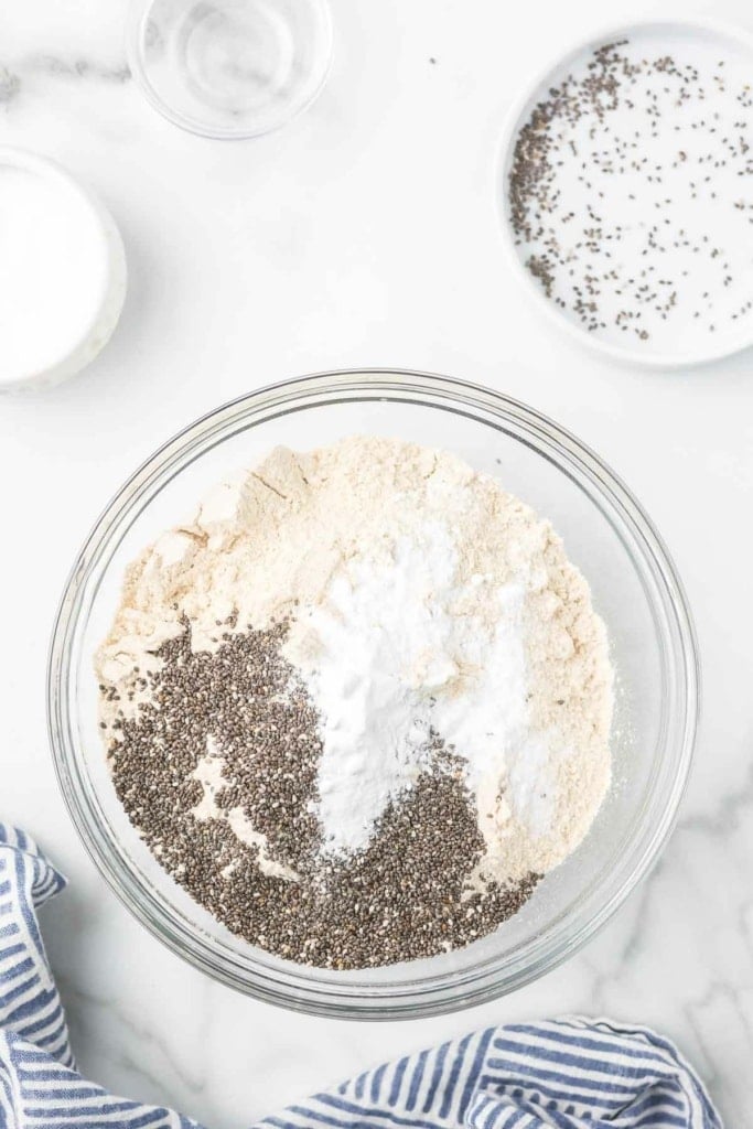 white whole wheat flour, chia seeds, and other dry baking ingredients in a glass bowl