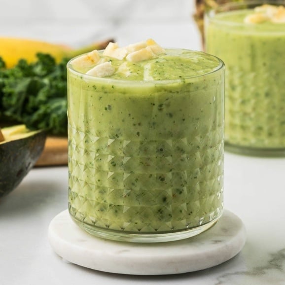 banana avocado smoothie with kale in a short glass