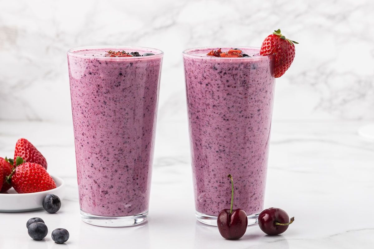two mixed berry smoothies with Greek yogurt and chia seeds in tall glasses