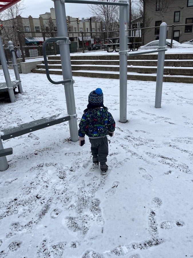 toddler in snowy playground