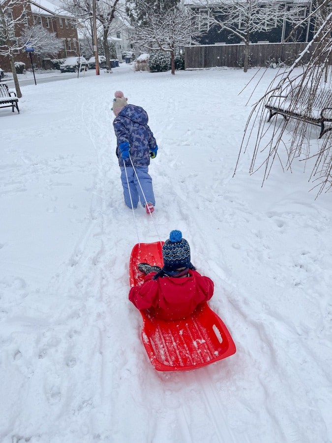 kid pulling another kid in sled