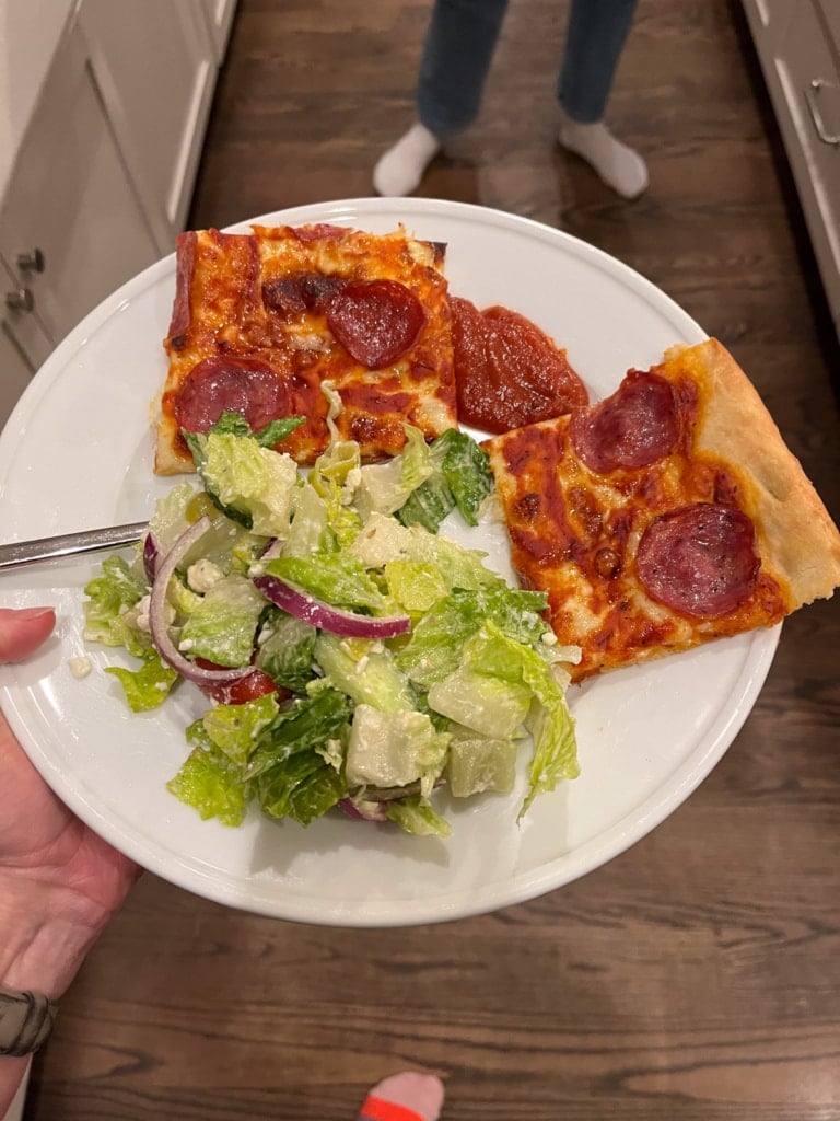 pizza with salad on a plate.