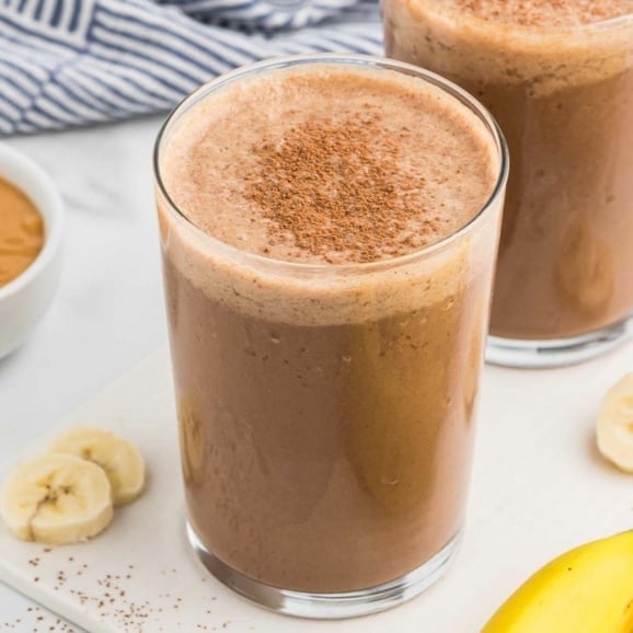 chocolate peanut butter banana smoothie with protein powder in a glass