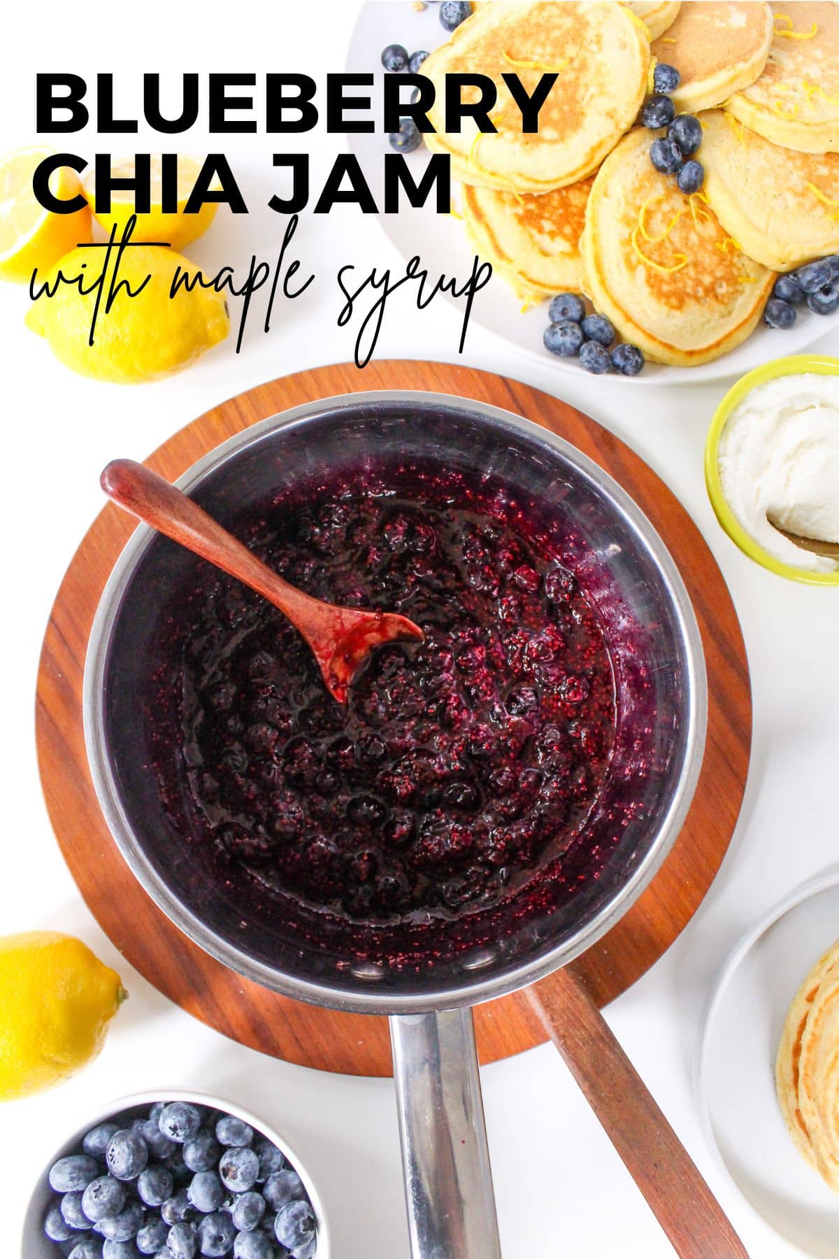 blueberry chia jam in a metal saucepan with lemons beside it