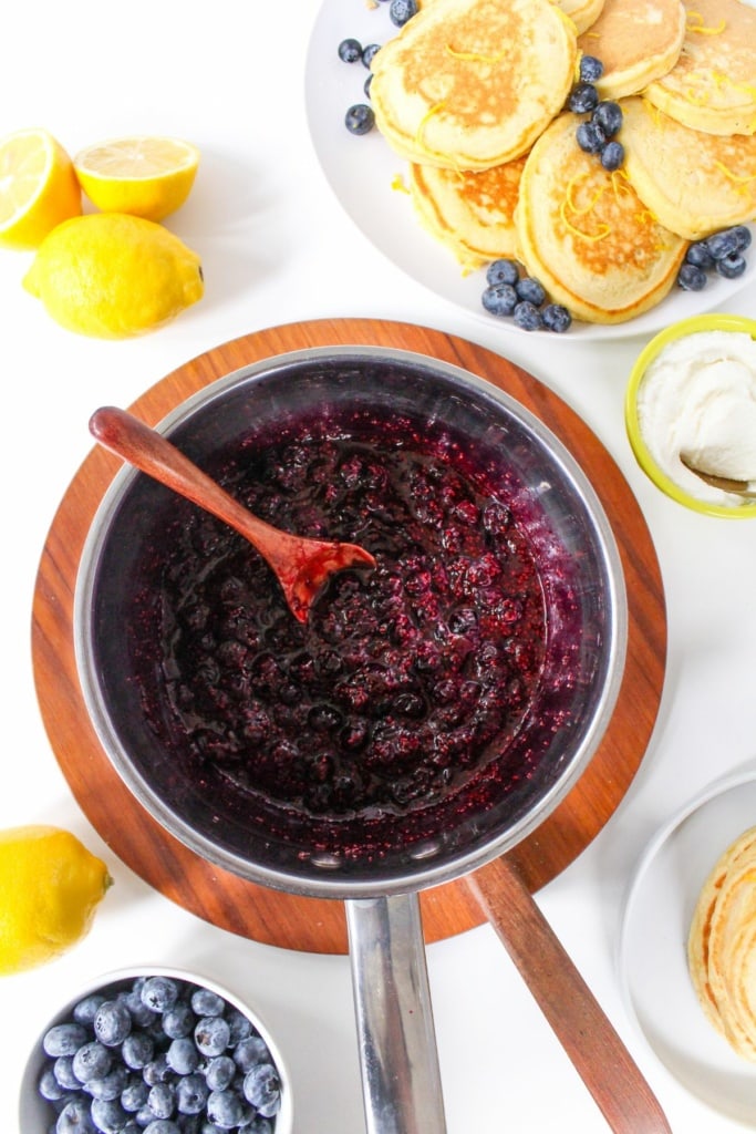 blueberry chia jam in a metal saucepan with lemons beside it