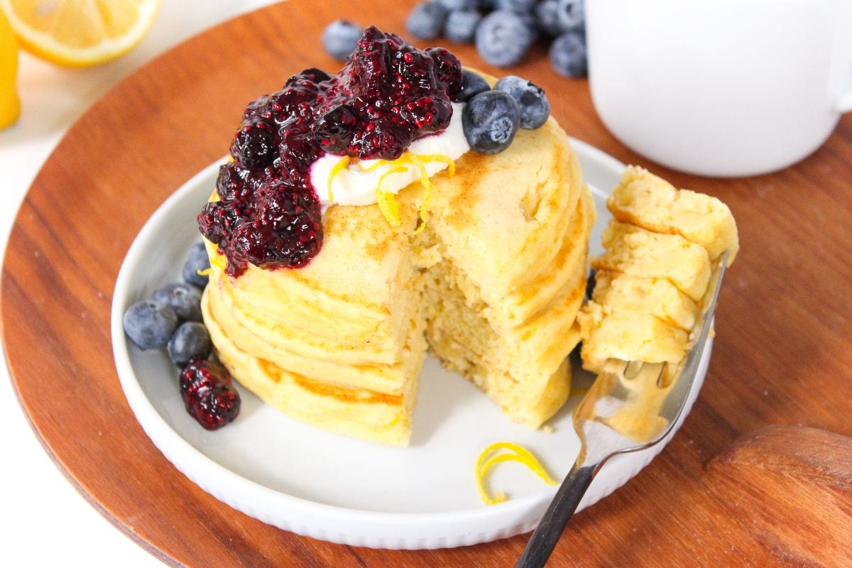 a stack of lemon ricotta pancakes topped with blueberry chia jam
