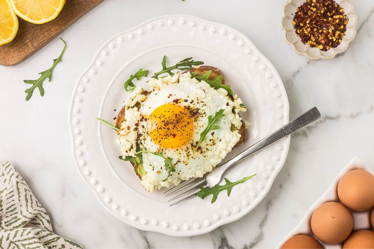 a crispy feta fried egg on avocado toast with arugula