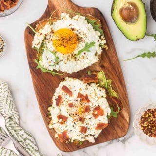 crispy feta fried eggs with avocado and bacon on a wooden platter