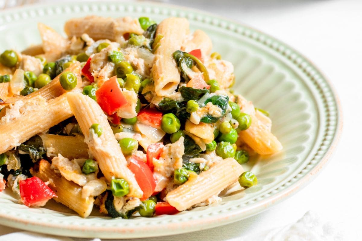tuna noodle casserole with vegetables in a shallow light green bowl