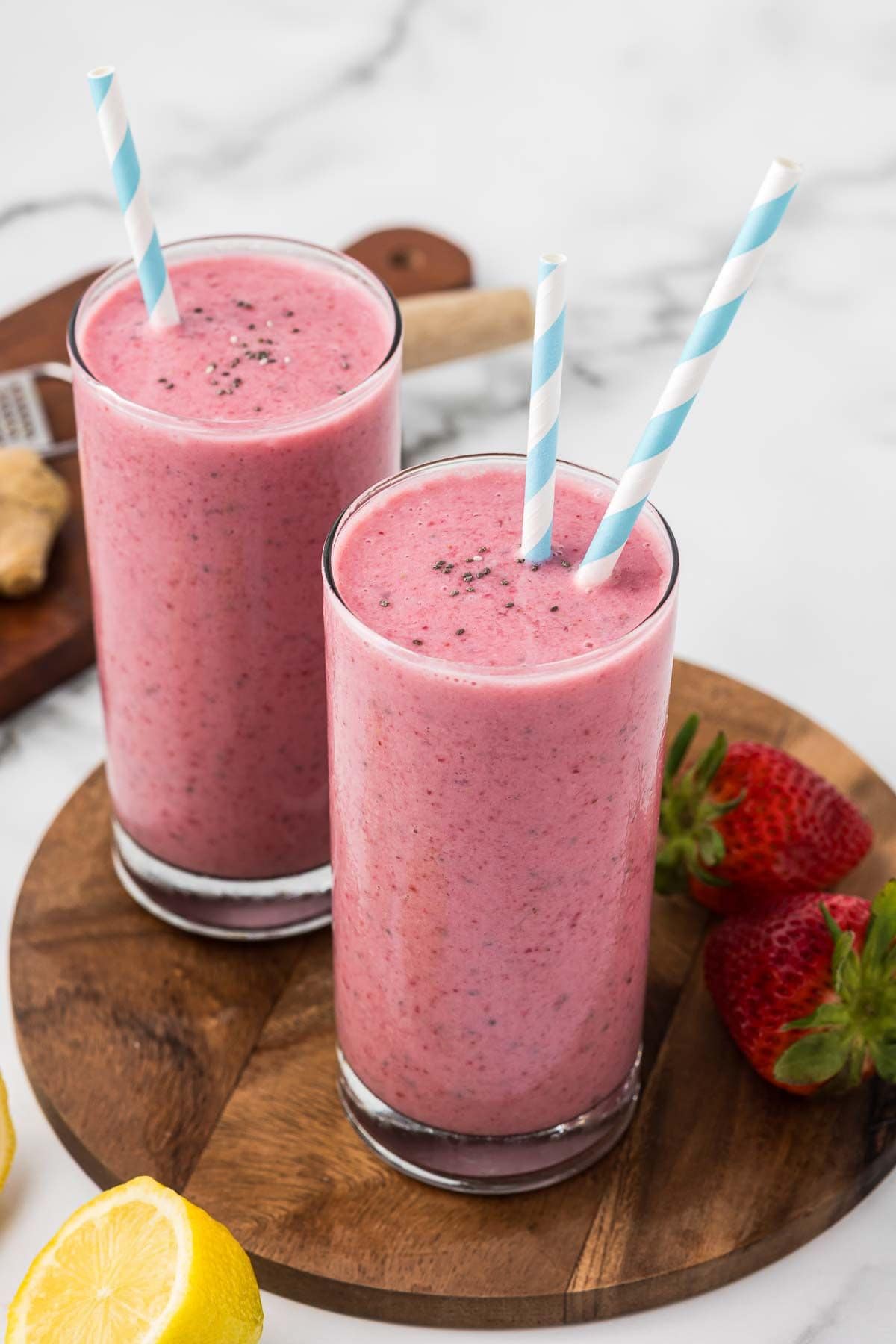 pink smoothie with strawberries, bananas, and beets in tall glasses